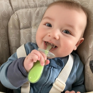 Baby with spoon smiling