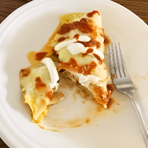 Chicken Enchiladas on plate with a fork