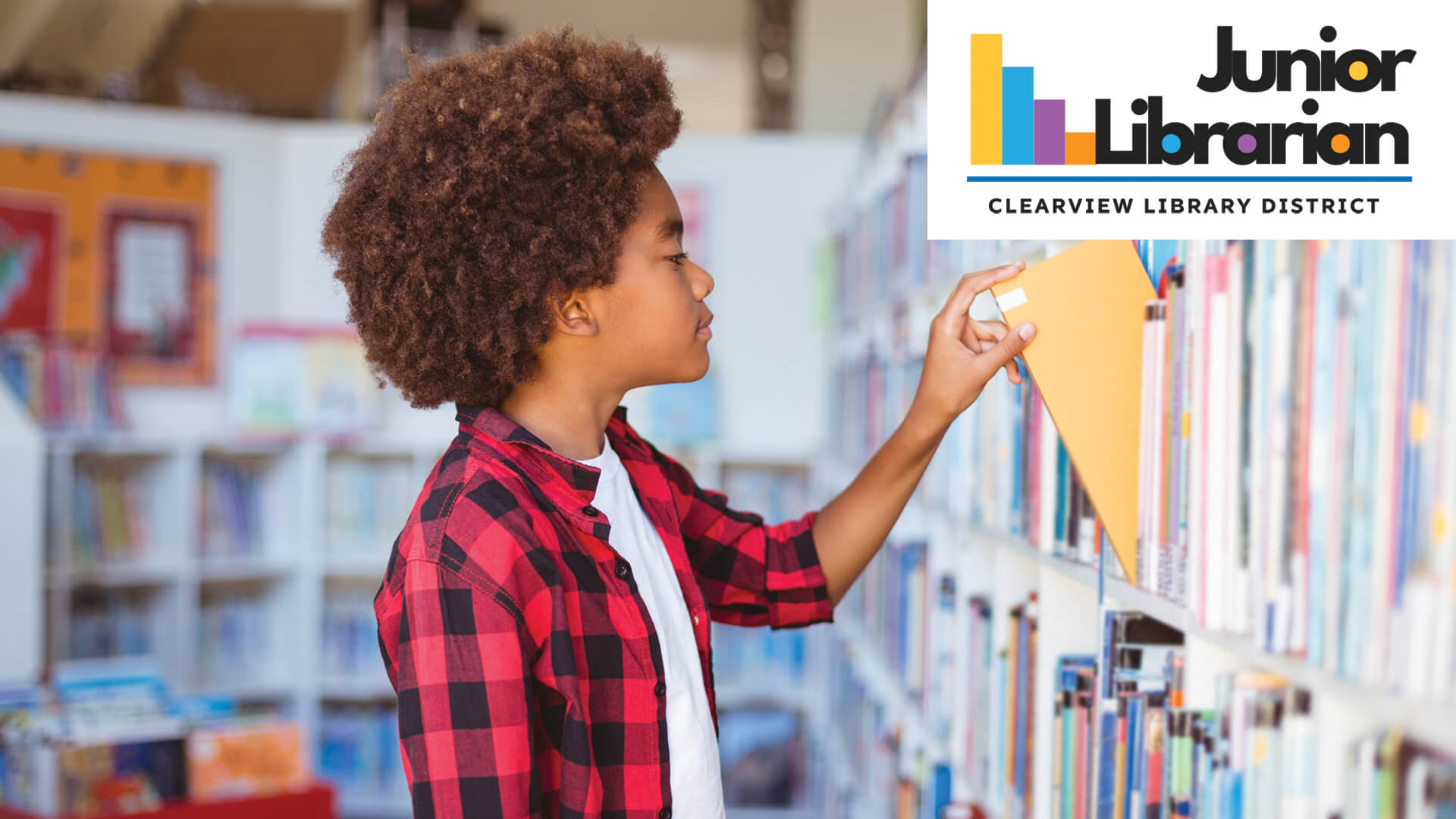 Boy browsing books on library shelf