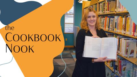 woman standing in library with open book