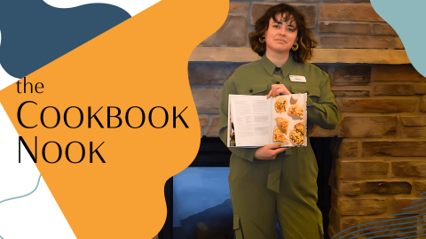 Woman holding a cookbook by fireplace