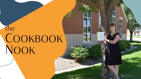 Woman outside under a tree with a book