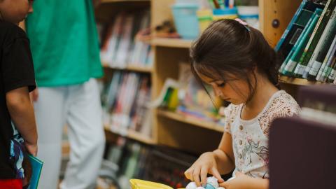 child sitting and reading on bookmobile