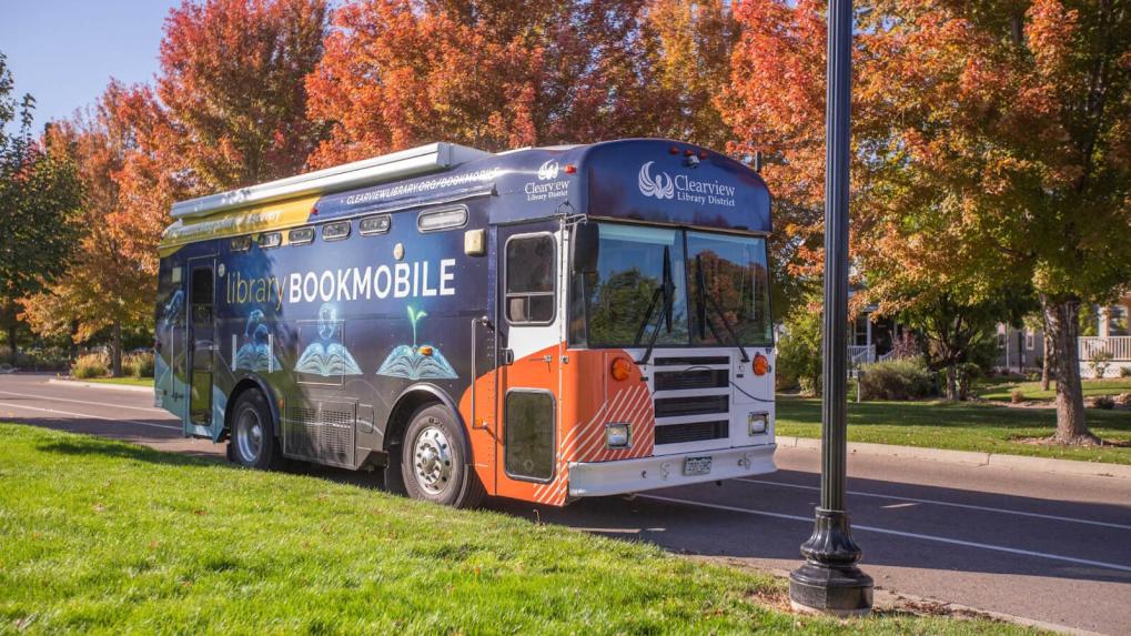 Bookmobile parked under fall trees