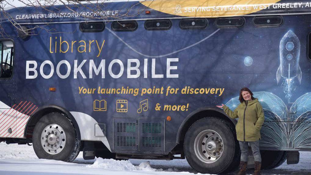 woman standing by a bookmobile.