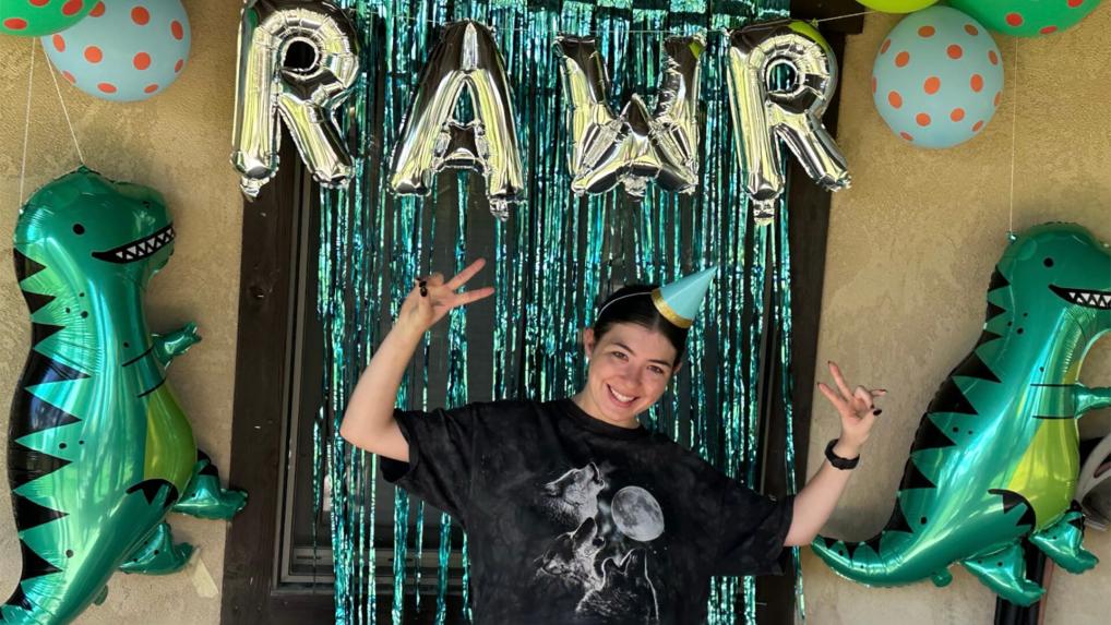 Woman standing in front of a RAWR sign