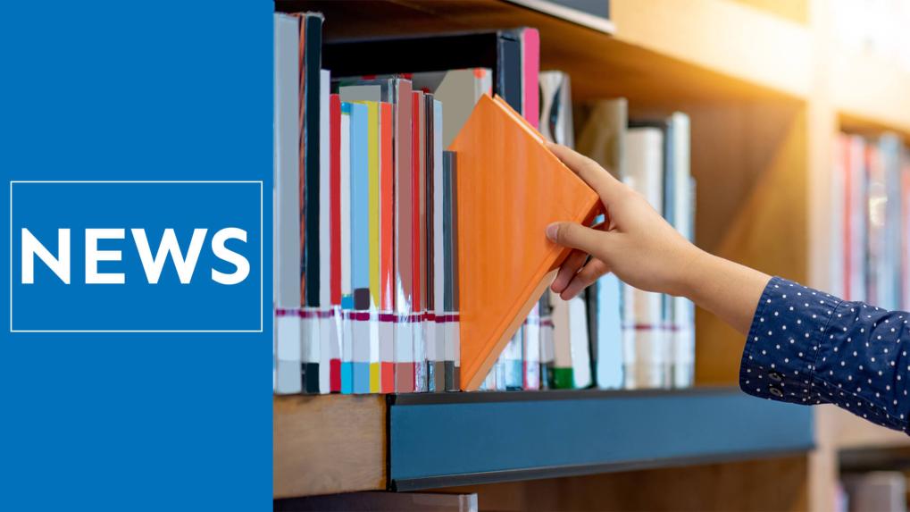 Hand taking book off library shelf