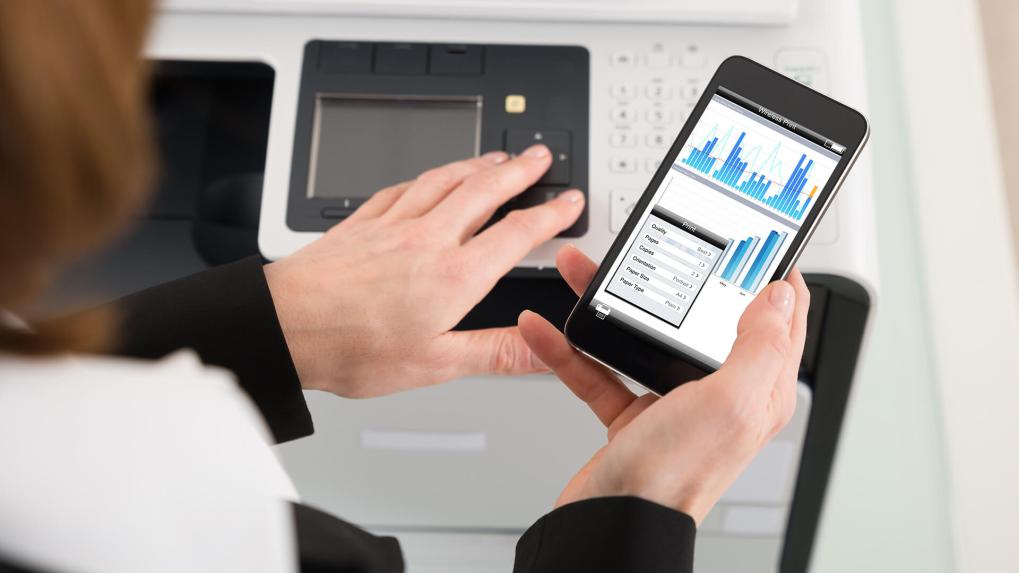 Woman printing from phone to copier.