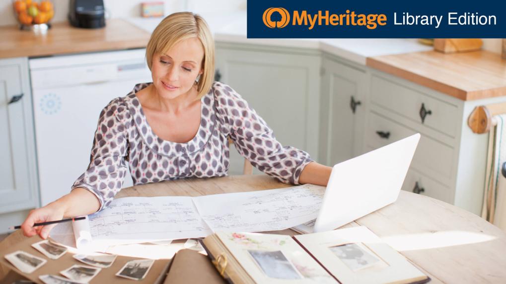 Woman at kitchen table doing genealogy research.
