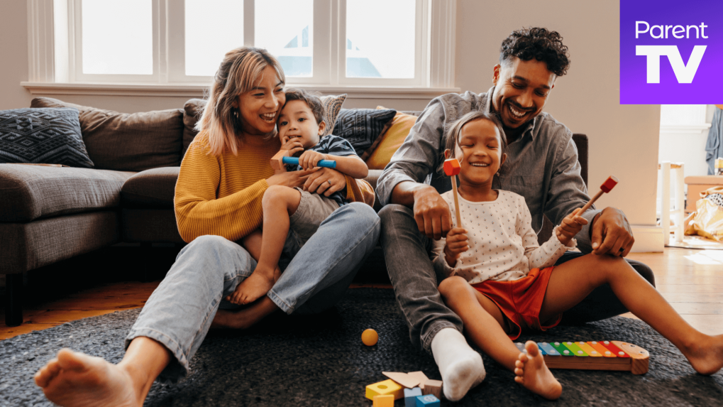 Mother and father playing with kids in the living room. 