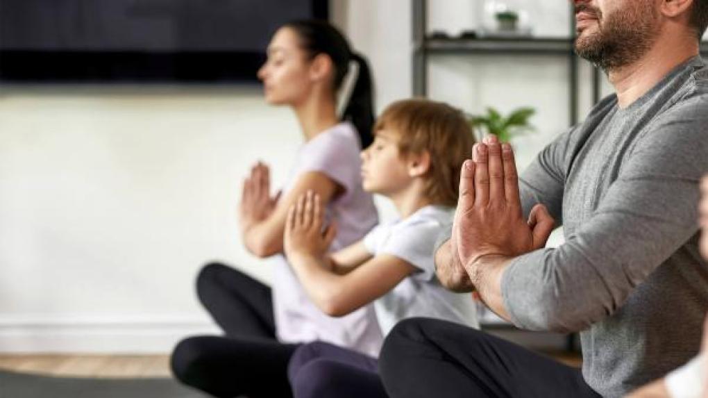 Family sitting in yoga pose.